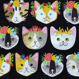 May include: A repeating pattern of cat faces on a black background. Each cat face is decorated with a floral crown. The cats have various colors, including white, gray, yellow, and brown. The floral crowns feature red, pink, yellow, and blue flowers.