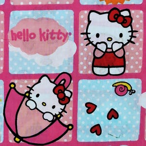 May include: Pink and blue patterned fabric featuring Hello Kitty characters. The design includes Hello Kitty in various poses, hearts, and the text "hello kitty". The background has a polka dot pattern.