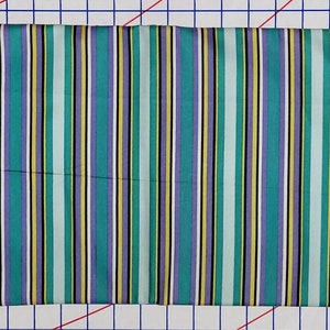 May include: Striped fabric in shades of teal, purple, yellow, white, and black. The fabric is 44 inches wide and is part of the "Donna Wilder for Fabric Traditions" collection.