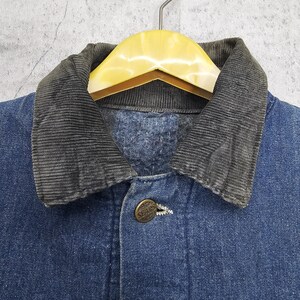 Puede incluir: Una chaqueta vaquera azul con cuello de pana. La chaqueta tiene cierre de botones y un solo bot&oacute;n en el pecho.