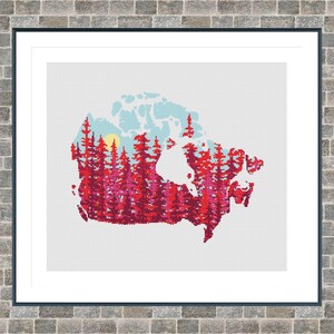 May include: Framed art print featuring a stylized map of Canada. The map is filled with a forest of red and pink trees, with a yellow sun and blue sky in the background. The artwork is framed in a black frame.