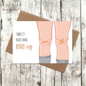 May include: A white card with the text "Take it nice and knee-sy" and an illustration of two legs with bandages on the knees.