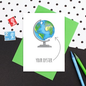 May include: A white card with a black outline of a globe on a stand. The globe is blue and green with a white arrow pointing to the right. The text "YOUR OYSTER" is written below the globe.