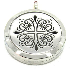 May include: A silver pendant with an ornate, openwork design. The pendant features a central cross motif with swirling, floral-like patterns. The round pendant has a polished finish and a small loop at the top for a chain.