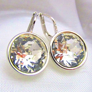 May include: A pair of silver earrings with clear crystal stones. The stones are round and have a faceted design.