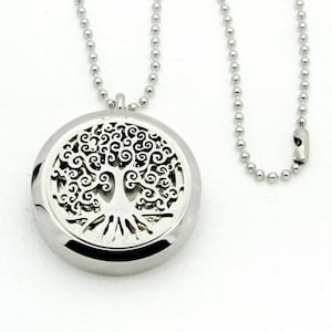 May include: A silver necklace with a round pendant featuring a tree of life design. The pendant has an openwork design with a delicate tree silhouette.