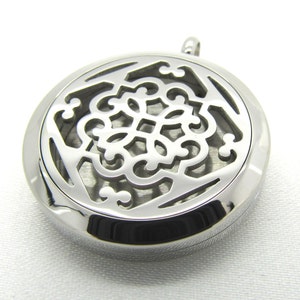 May include: Silver round pendant with a decorative filigree design. The pendant has a small opening on the side for adding essential oils.
