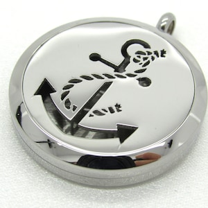 May include: Silver round pendant with an anchor design. The anchor is cut out of the metal and has a rope design around it.