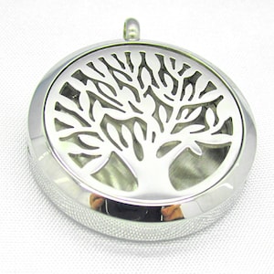 May include: A silver-toned metal pendant in the shape of a tree of life. The pendant has a round, open design with a smooth, reflective surface.