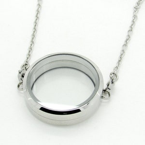 May include: A silver locket necklace with a round, clear glass insert. The chain is silver and has a lobster clasp.