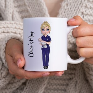 K&ouml;nnte beinhalten: Eine wei&szlig;e Keramiktasse mit einer Cartoon-Illustration einer blonden Krankenschwester, die ein Baby h&auml;lt. Der Text "Claire's Mug" ist auf der Seite der Tasse aufgedruckt.