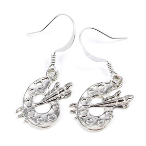 May include: Silver dangle earrings featuring a small paint palette with a paintbrush.