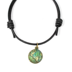 May include: A black leather bracelet with a knotted closure and a small globe charm. The globe is made of metal and has a green and blue enamel finish.