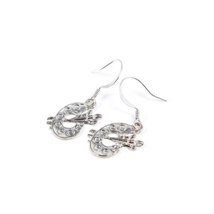 May include: Silver earrings shaped like a paint palette with a paintbrush on top.