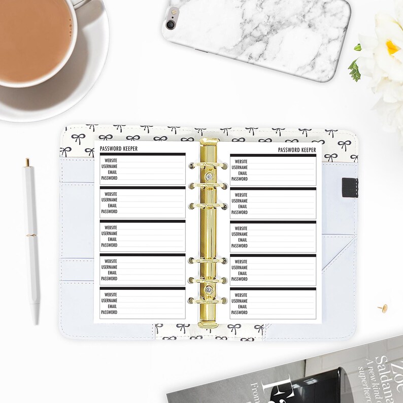 Personal size password keeper planner inserts laid open in a ring binder, gold six-ring mechanism, paired with a marble phone case and coffee mug on a styled workspace. Made-to-order in the USA by CityGirl Planners. Physical inserts only no binder or accessories included.
