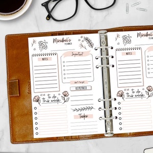 May include: A white planner with a brown leather cover. The planner has a tabbed section for "Important", "Remember", "Tasks", and "Notes". The planner also has a section for "To do this week".