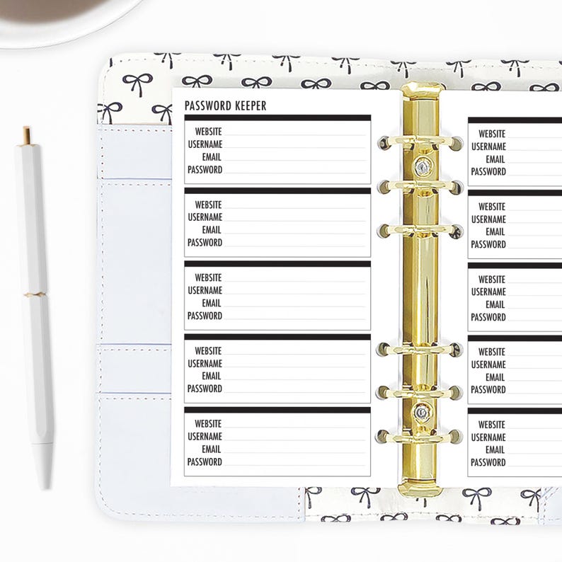 Personal password keeper planner refills shown in a ring binder, gold rings open across a two-page spread with rows of Website, Username, Email, and Password fields, styled with a white pen on a bow-print desktop. Hand-cut and bound in our small studio. Physical refills only no binder or accessories included.