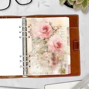 May include: Open brown leather binder with a floral insert featuring pink roses and vintage script. The binder has silver rings and a tabbed divider. The overall aesthetic is romantic and vintage, suitable for planners or journals.