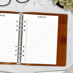 May include: A brown leather bound planner with a silver ring binder. The planner is open to a page with the title "To Do List" and lined paper for writing.