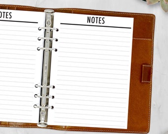 May include: A brown leather bound notebook with a silver binder and lined pages. The notebook is open to a page with the word "NOTES" printed at the top.