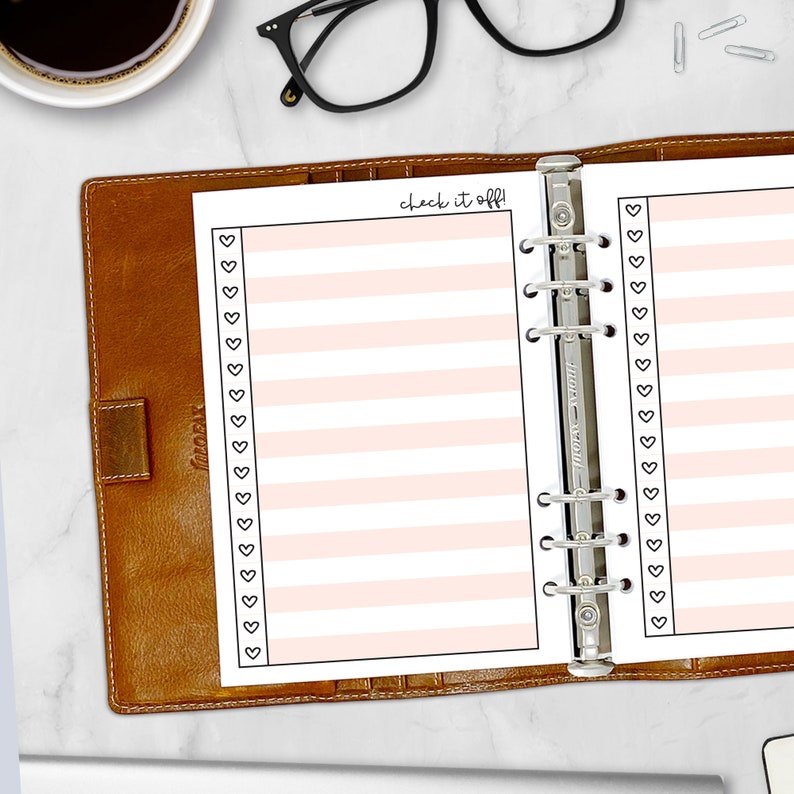Printed A5 Check It Off checklist planner insert in Peach shown in a tan leather ring binder on a marble desk. Peach striped design with heart checkboxes. Physical paper insert only -- binder and accessories not included. Planner insert is made in the USA by CityGirl Planners.