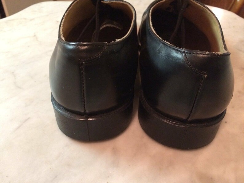 May include: A pair of black leather lace-up shoes with a rounded toe and a thick sole.