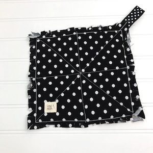 May include: Black and white polka dot fabric pot holder with a frayed edge and a white fabric tag that says "Love Life Handmade".