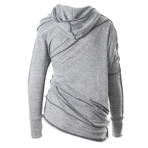 May include: Gray hooded sweatshirt with long sleeves and a diagonal seam detail. The sweatshirt has a relaxed fit and a slightly asymmetrical hem.