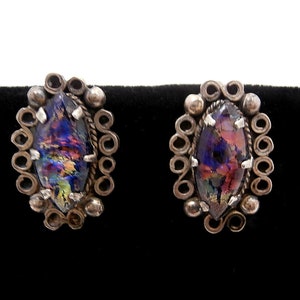 May include: A pair of silver earrings with iridescent glass stones set in a filigree design.