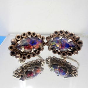 May include: A pair of silver earrings with a colorful opal stone set in a decorative silver frame.