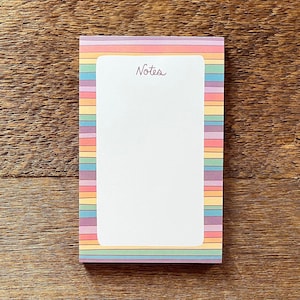 May include: A rainbow striped notepad with the word "Notes" printed at the top.