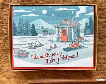 May include: A Christmas card with a winter scene of a cabin on a frozen lake. The card reads "We wish you a Merry Fishmas!"
