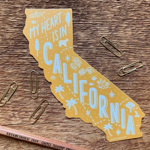 May include: A yellow outline of the state of California with the text "My heart is in California" and various illustrations of palm trees, mountains, and stars.