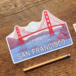 May include: A red and white illustration of the Golden Gate Bridge with the text "Greetings from San Francisco".