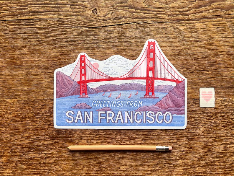 May include: A postcard featuring a red and white illustration of the Golden Gate Bridge in San Francisco, California. The postcard says "Greetings from San Francisco".