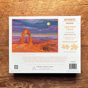 May include: A 1,000 piece jigsaw puzzle featuring a scenic view of Delicate Arch in Arches National Park, Utah. The puzzle is made in the USA and measures 19.25 x 26.6 inches.