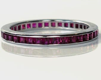 Anillo de eternidad antiguo con rubíes de talla cuadrada engastados en canal en oro blanco de 14 quilates.