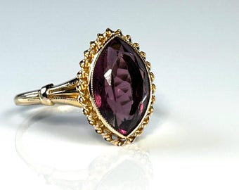 Anillo antiguo eduardiano con gema púrpura talla marquesa en forma de flor, engastado en oro amarillo.