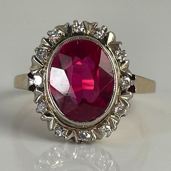 Anillo antiguo de oro de 14 quilates con halo de diamantes y rubíes engastados en bisel de poca altura y corte ovalado