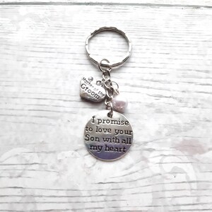May include: Silver keychain with a heart charm that says "Mother of the Groom" and a round charm that says "I promise to love your Son with all my heart".