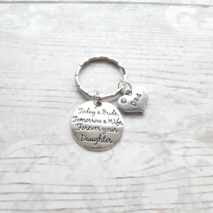 May include: Silver keychain with a round charm that reads "Today a Bride, Tomorrow a Wife, Forever your Daughter" and a small heart charm that reads "Dad".