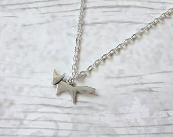 May include: A silver chain necklace with a silver fox pendant. The fox is stylized and has a simple design.