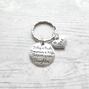 May include: Silver keychain with a round charm that reads "Today a Bride, Tomorrow a Wife, Forever your Daughter" and a small heart charm that reads "Dad".