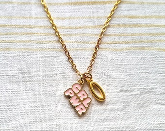 May include: A gold chain necklace with a pink enamel pendant that says "Girl Power" and a small gold ring charm.