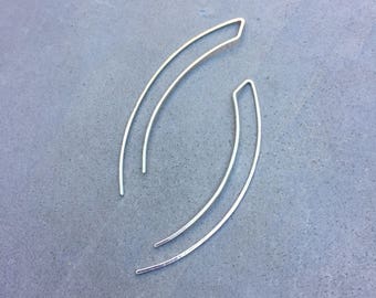 May include: A pair of silver earrings with a curved, open design.