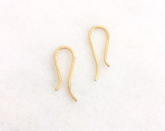 May include: Two gold-toned earring hooks. The hooks are made of metal and have a simple, elegant design.