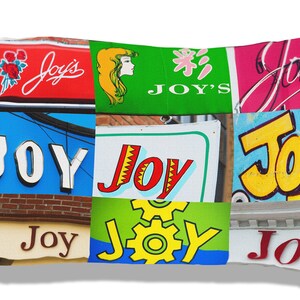 May include: A collage of colorful signs with the word "Joy" displayed in various fonts and styles. The signs are arranged in a grid pattern and feature different colors, including red, blue, green, yellow, and pink.