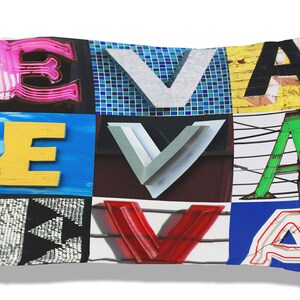 May include: A white pillow with a colorful collage of the letters "EVA" printed on it. Each letter is made up of different textures and patterns, including neon signs, brick walls, and metal.