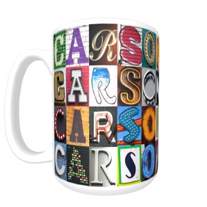 Puede incluir: Taza de cerámica blanca con un diseño colorido que presenta el nombre "CARSON" escrito en diferentes fuentes y colores. Cada letra está compuesta por un collage de letras coloridas, estampadas y texturizadas.