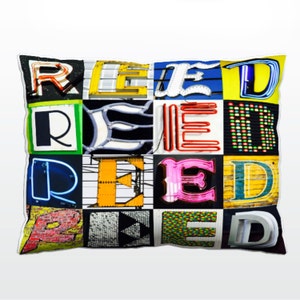 Könnte beinhalten: Ein farbenfrohes Kissen mit dem Wort "REED" in verschiedenen Schriftarten und Farben. Die Buchstaben bestehen aus Neon-Schildern, bemaltem Holz und anderen Materialien.